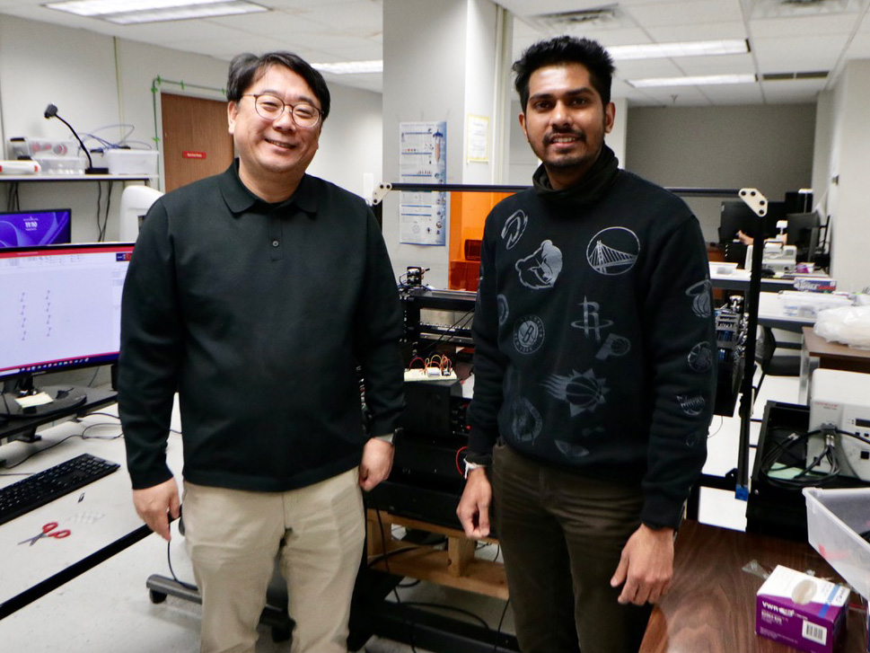 Professor Daeha Joung and Ph.D. student Udena Epitawala Arachchige standing in a lab