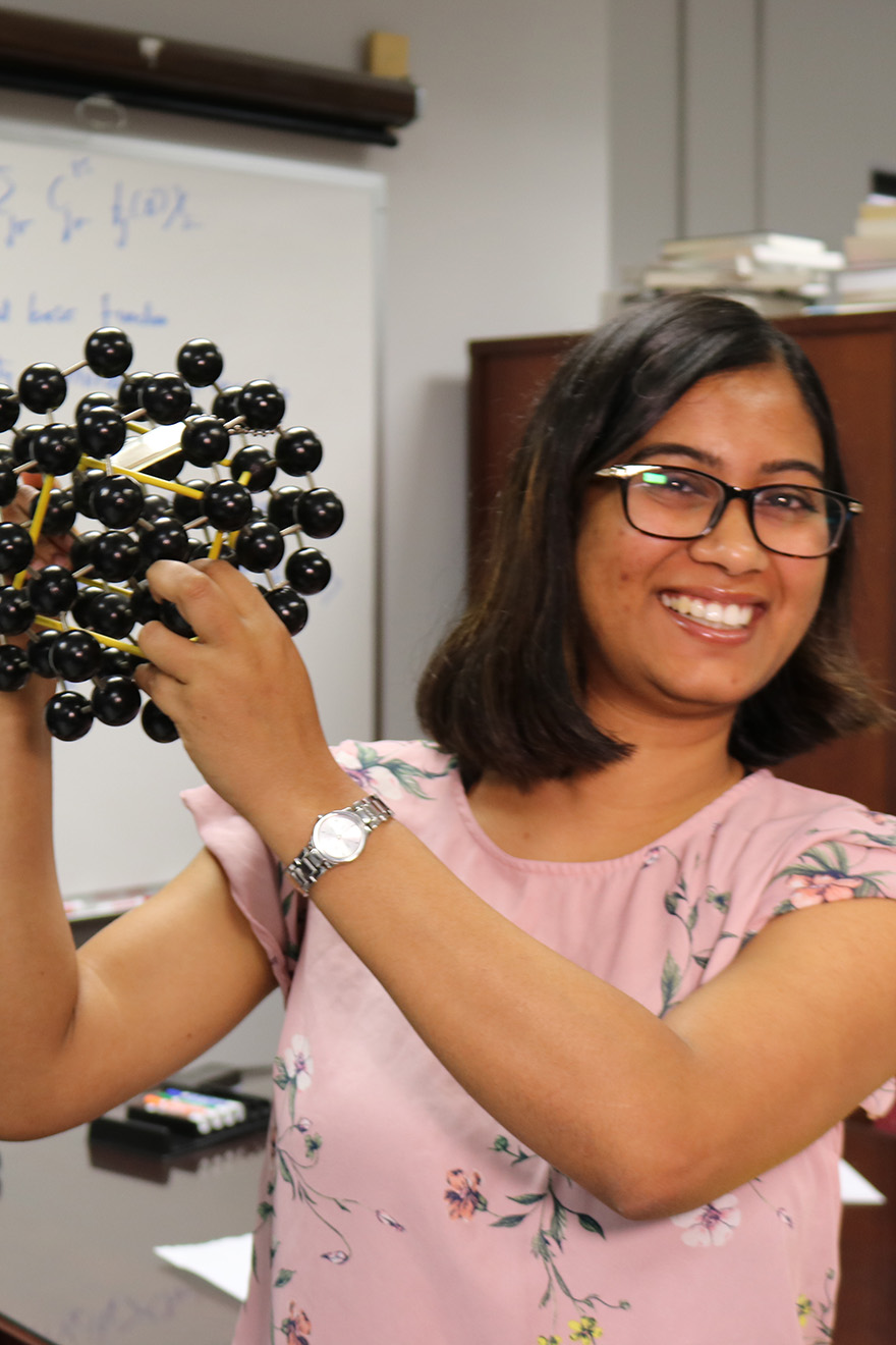 Student holds up model of molecule