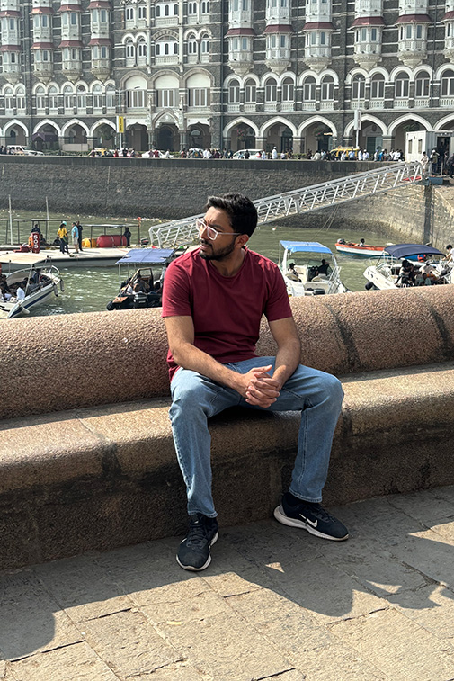 Rehan Adatia sits beside the water in a city